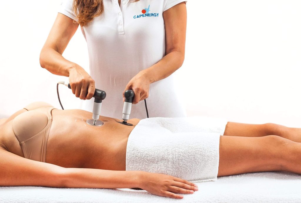 Fisioterapeuta haciendo tratamiento de reduccion de abdomen con radiofrecuencia estetica en Palma de Mallorca